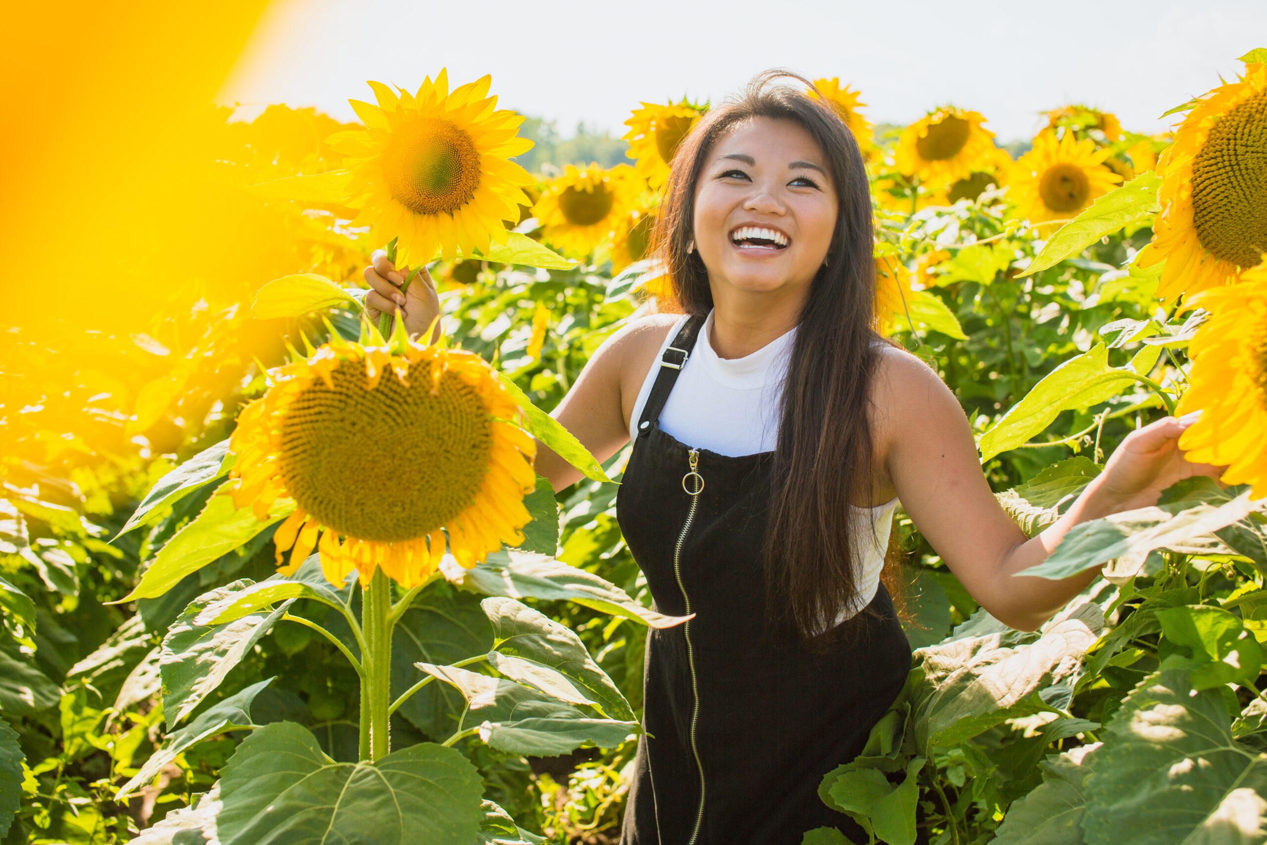 Joyful Woman surrounded by sunflowers